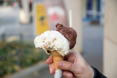 Vanilyalı ve çikolatalı bir dondurmayı tutarken