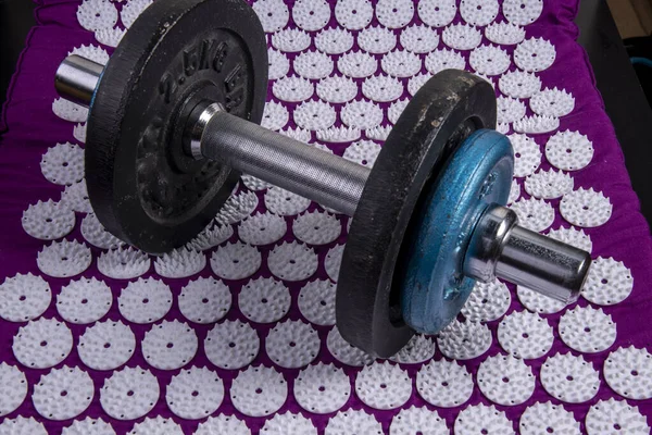 Dumbbell on an acupressure mat