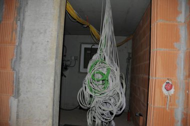 Yeni bir binaya kablolar döşenmiş Tavandan kablolar çıkıyor