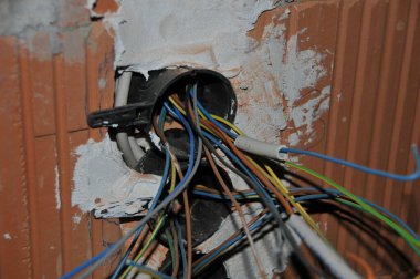 Yeni bir binada elektrik işi. Duvardan kablolar çıkıyor.