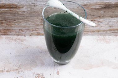 Bir bardak suya karıştırılmış yeşil gıda takviyesi