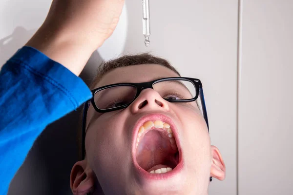 Criança Com Óculos Goteja Remédio Pipeta Para Boca — Fotografia de Stock