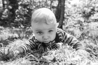 Parktaki çimlerde oturan küçük bebek