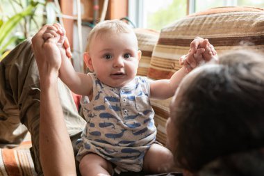 Evde babanın elini tutan tatlı çocuk.
