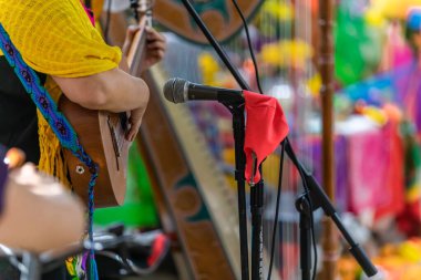 Gitar çalan kadına doğru maskeli mikrofon