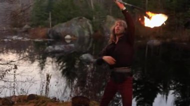 Ateş çubuğu kullanan ve alevlere çarpan adam.