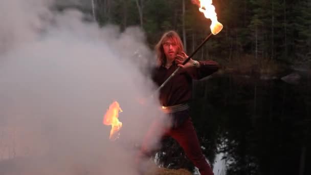 Młody człowiek tańczy z pałką ognia i dymem — Wideo stockowe