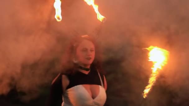 Женщина танцует с металлическими рогами и огненной веревкой — стоковое видео