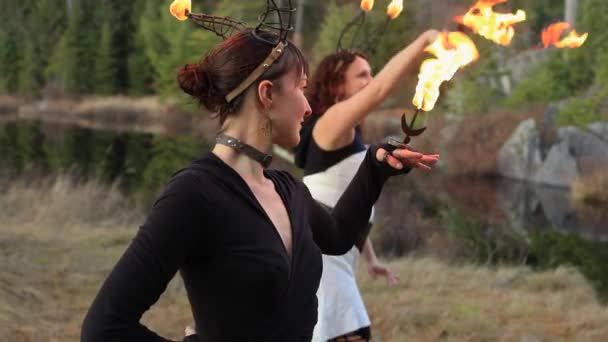 Deux femmes dansent avec le feu sur la corne métallique — Video