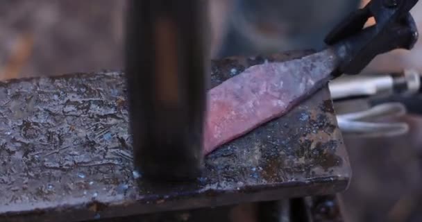 Кузнец делает нож из гвоздя железной дороги — стоковое видео