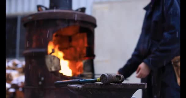 Hammer on anvil with woman near forge burner — Stock Video