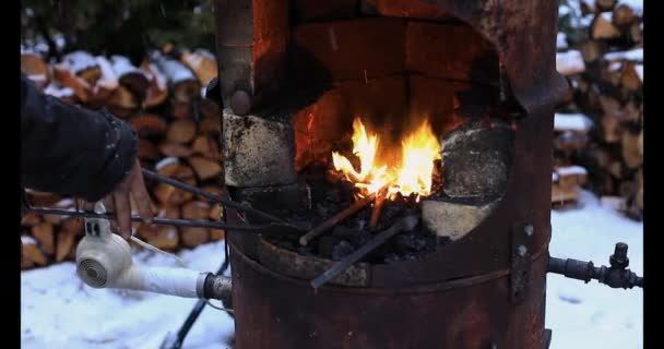 Samice trzymające pręt żelazny w kuźni zimą — Wideo stockowe