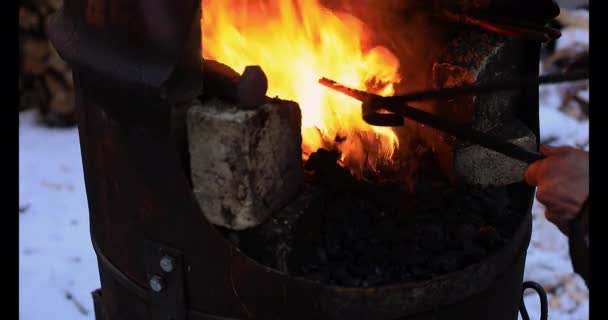 Mulher mão adicionando carvão na forja para chama — Vídeo de Stock