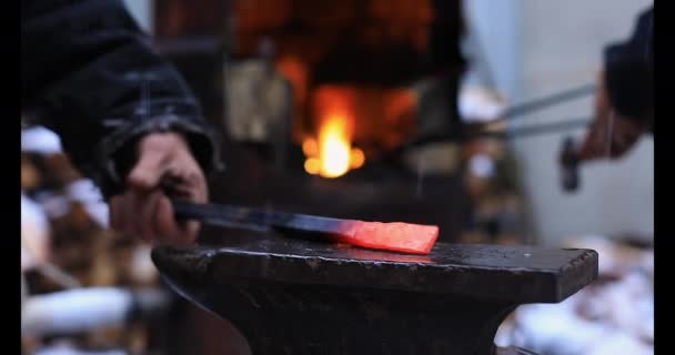 Blacksmith Hands hitting hammer on iron rod on anvil — Stock Video