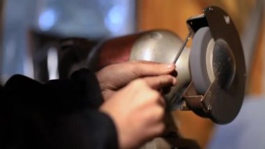 Dönen değirmen taşında parlayan eller