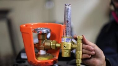 Kaynak makinesi basınç göstergesini ayarlayan kadın