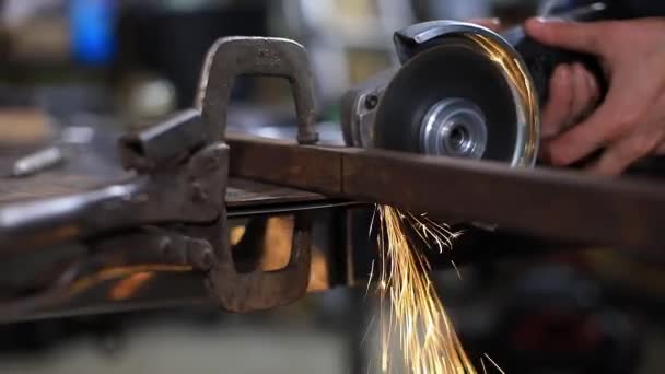 Female blacksmith grinding iron pipe — Stock Video
