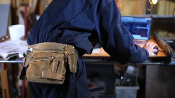 Female craftswoman with belt using laptop — Stock Video
