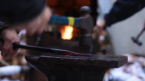 Женщина бьет молотком по железу на наковальне — стоковое видео