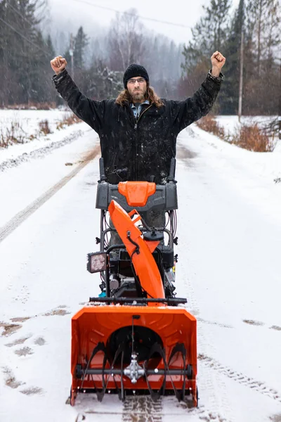 Young man playing with a snowplough in the winter — Stock Photo, Image