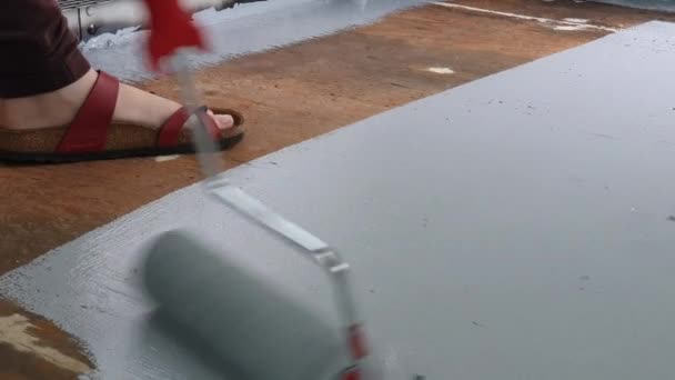 Egy személy, aki görgővel festi a padlót — Stock videók