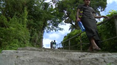 Halkın önünde taş bir merdivende yürüyor