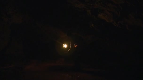 Karanlık ve sulu bir mağarada bir adam — Stok video