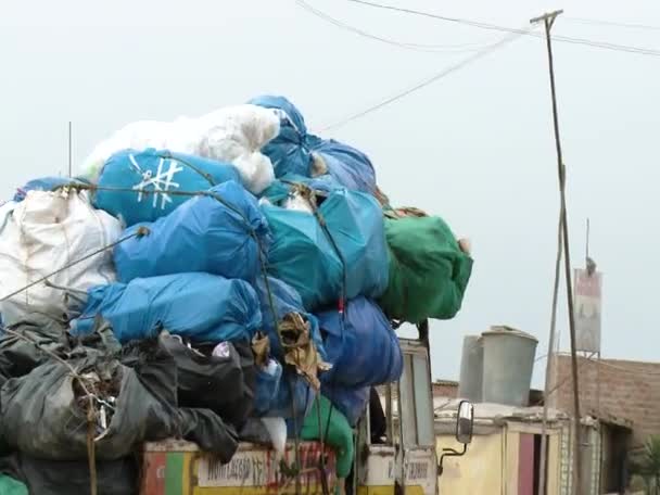 Geladen vuilniswagen passeert een weg — Stockvideo