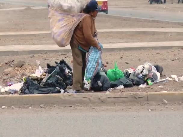 Pobre mulher pegando sacos de lixo na beira da estrada — Vídeo de Stock