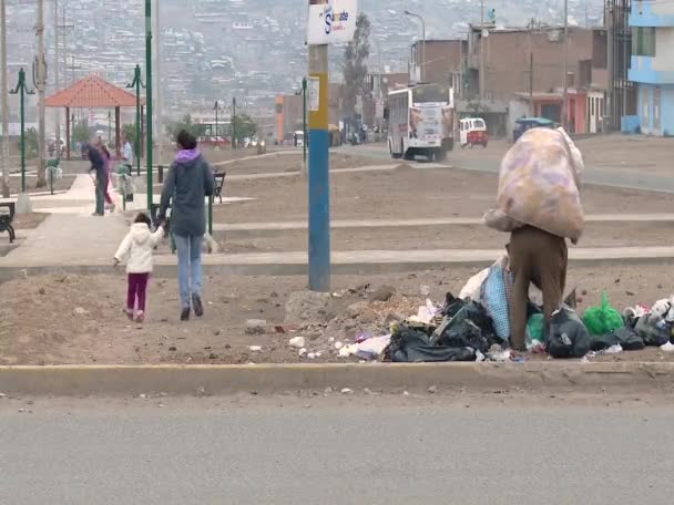 Poor woman picking up trash in a city — Stock Video