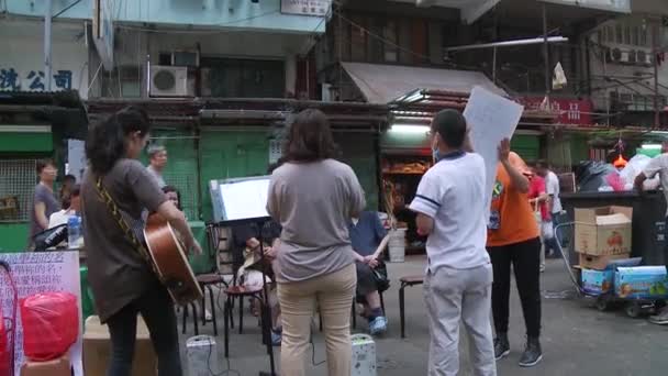 Музыканты, играющие и поющие на рынке Гонконга — стоковое видео
