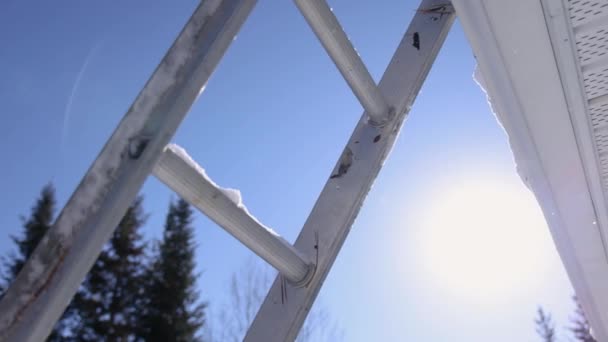 Ta bort nysnö från ett tak under en solig vinterdag — Stockvideo