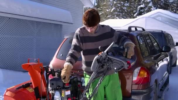 Joven quitando nieve con quitanieves mecánicos — Vídeos de Stock