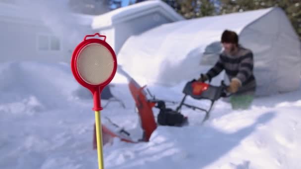 Młody człowiek usuwający śnieg mechanicznym pługiem śnieżnym — Wideo stockowe