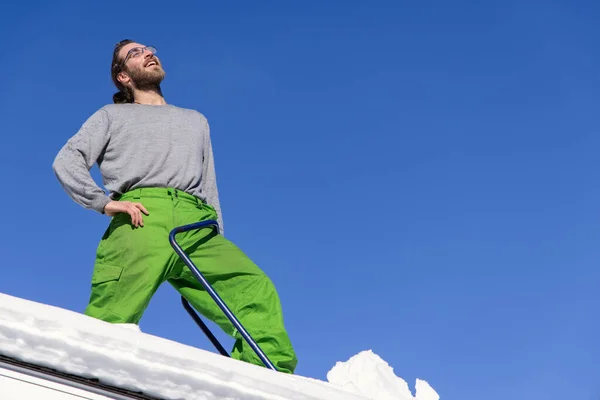 Manually removing fresh snow from a roof — Stock Photo, Image