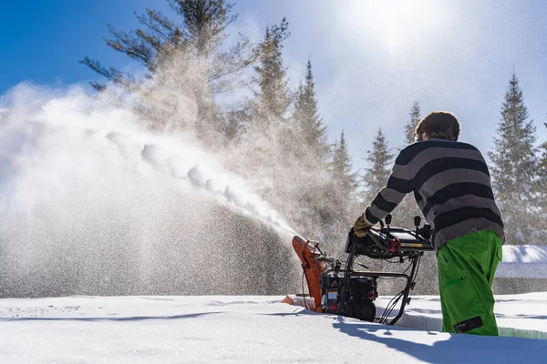Jongeman die sneeuw verwijdert met mechanische sneeuwploeg — Stockfoto