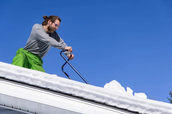 Remover manualmente neve fresca de um telhado — Fotografia de Stock