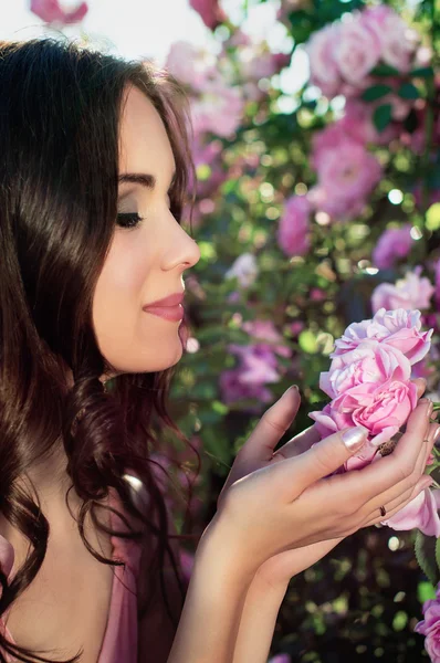 Lány a háttérben a rózsa a természetben — Stock Fotó
