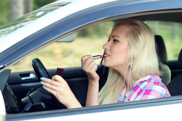 Ragazza dipinge le labbra al volante l'auto — Foto Stock