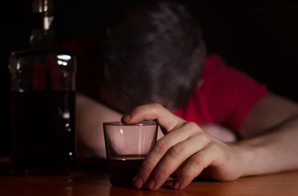 Dronken man in slaap aan een tafel Stockafbeelding