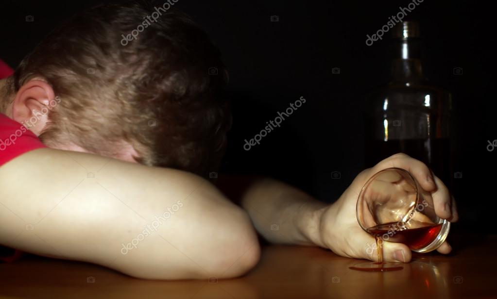 Drunk man asleep at a table. Alcoholism