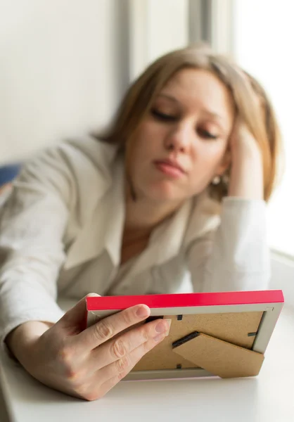 Beautiful girl is sad, sadness due the guy keep picture — Stock Photo, Image