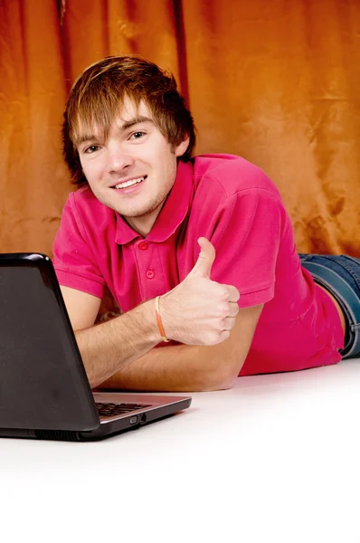 Piękny facet działa na laptopie pokazuje ok — Zdjęcie stockowe