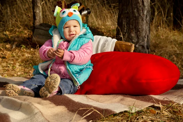 Herfst, een klein meisje met een stuk speelgoed rood hart — Stockfoto