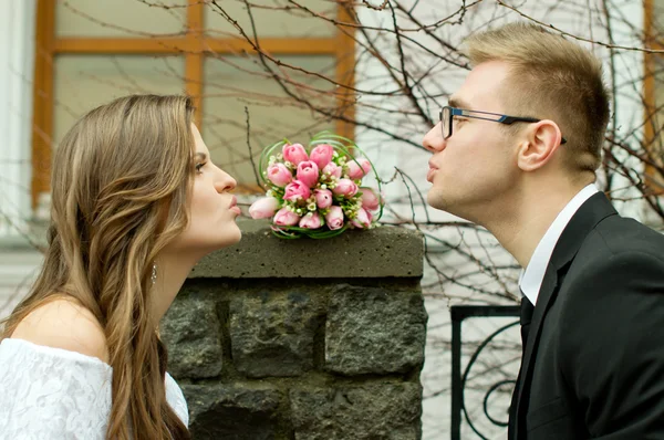 De echtgenoot en de bruid te geven elkaar een kus — Stockfoto