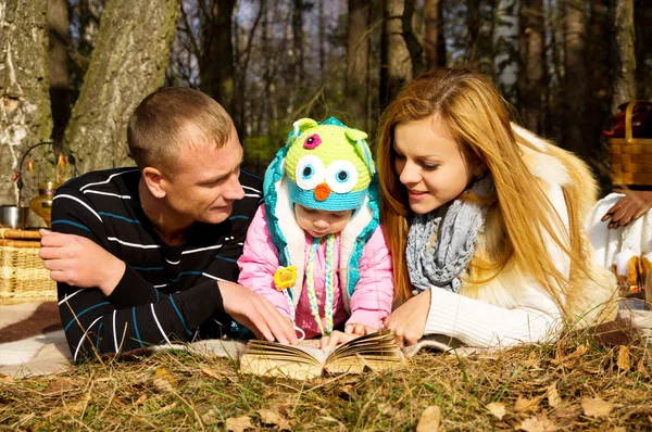 Νεαρή οικογένεια με μια κόρη στη φθινοπωρινή φύση — Φωτογραφία Αρχείου