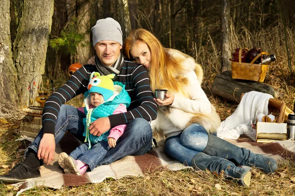 Young happy family outdoors in the woods — Stock Photo, Image