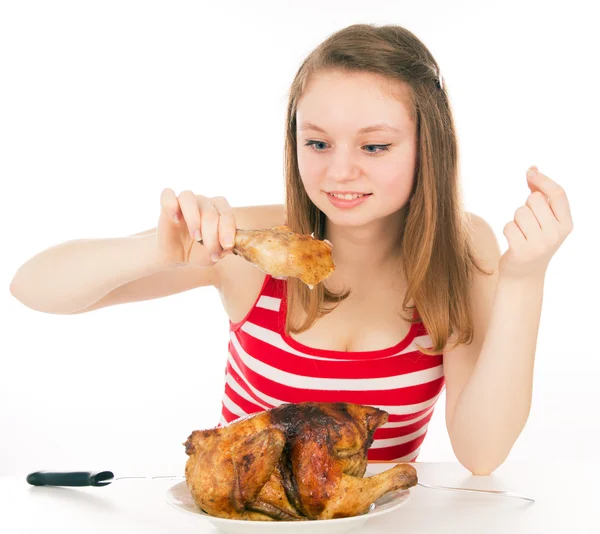 Jong meisje gretig eten een stuk van kip — Stockfoto