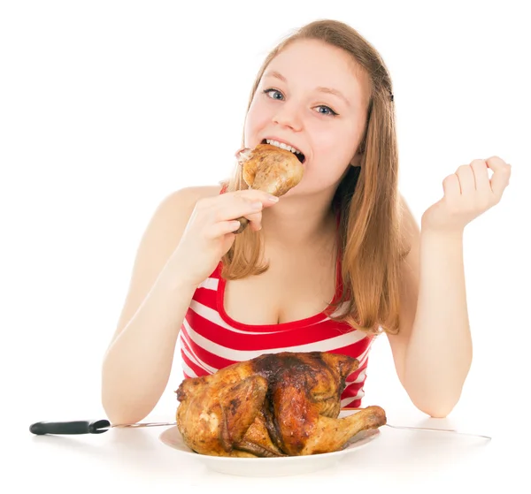 Mladá dívka hltavě jíst kousek kuřete — Stock fotografie