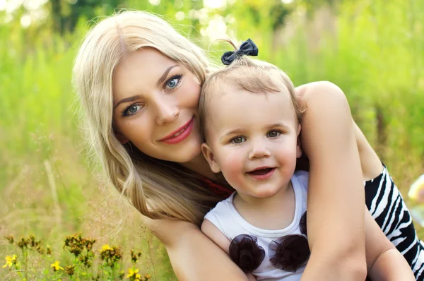 Portret van een mooie moeder met baby in de natuur — Stockfoto